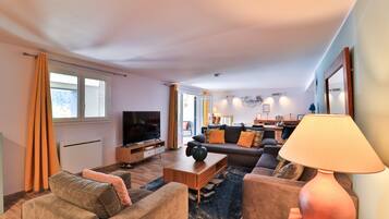 A modern living room with a sofa, coffee table, and TV.