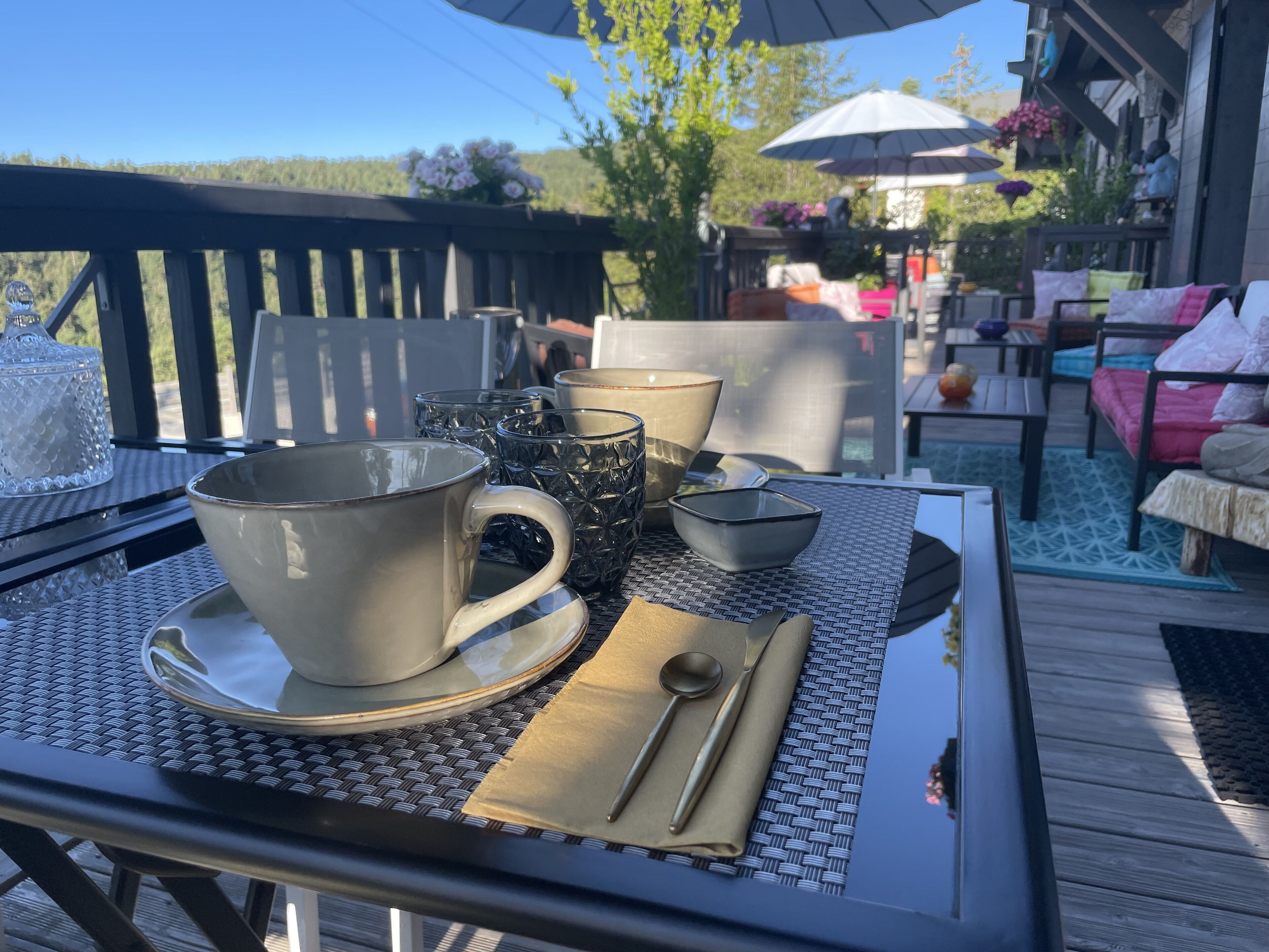 Ein Esstisch mit Geschirr, einer Tasse und einem Löffel auf einer gewebten Tischmatte.