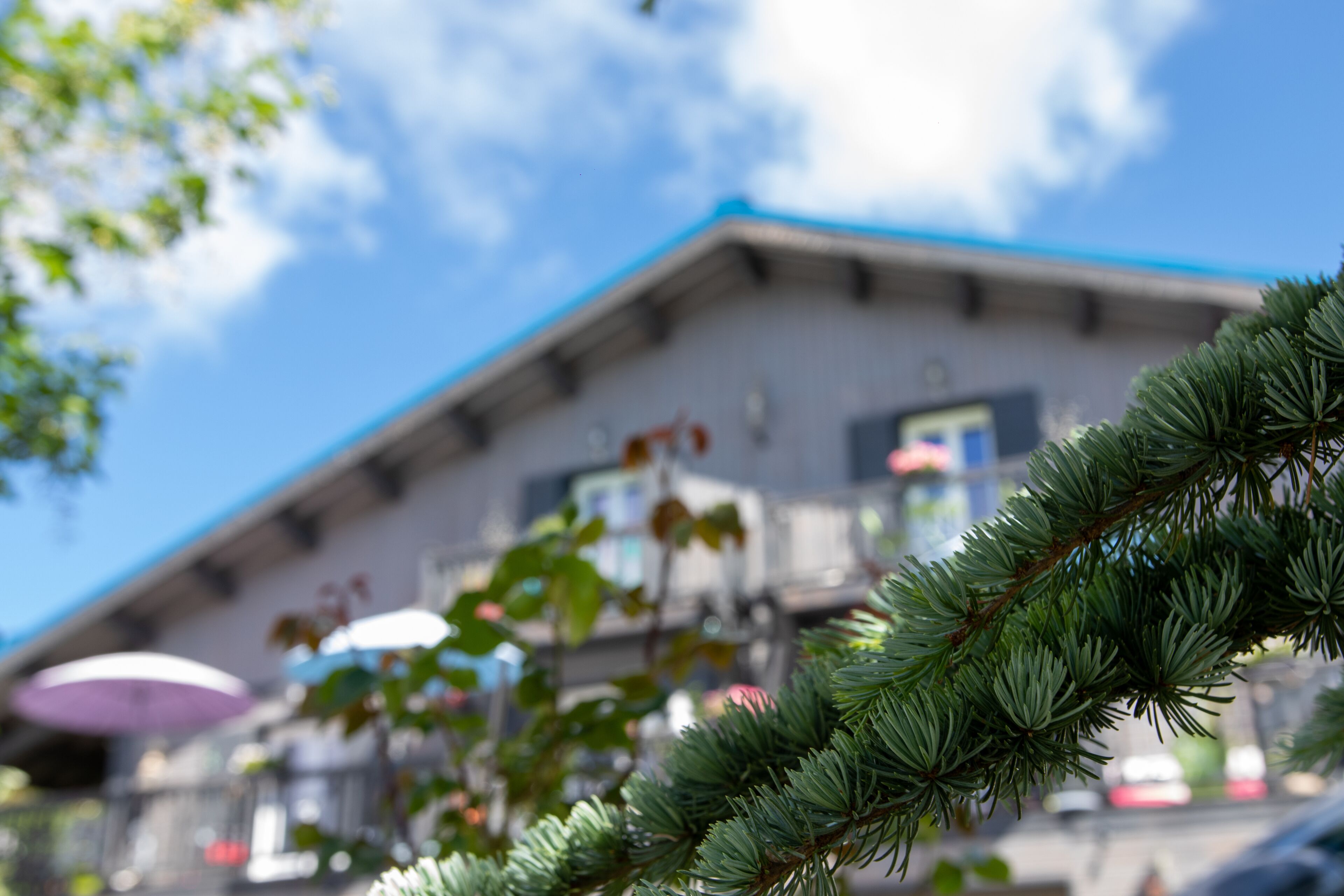 Ein Gebäude mit blauem Dach und einem Balkon.