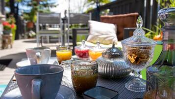 A table set outdoors with various glassware, a pitcher, and a sugar bowl.