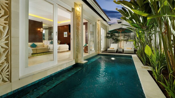 A modern hotel with a swimming pool, large windows, and indoor plants. - Bajra Bali Villa (Seminyak)