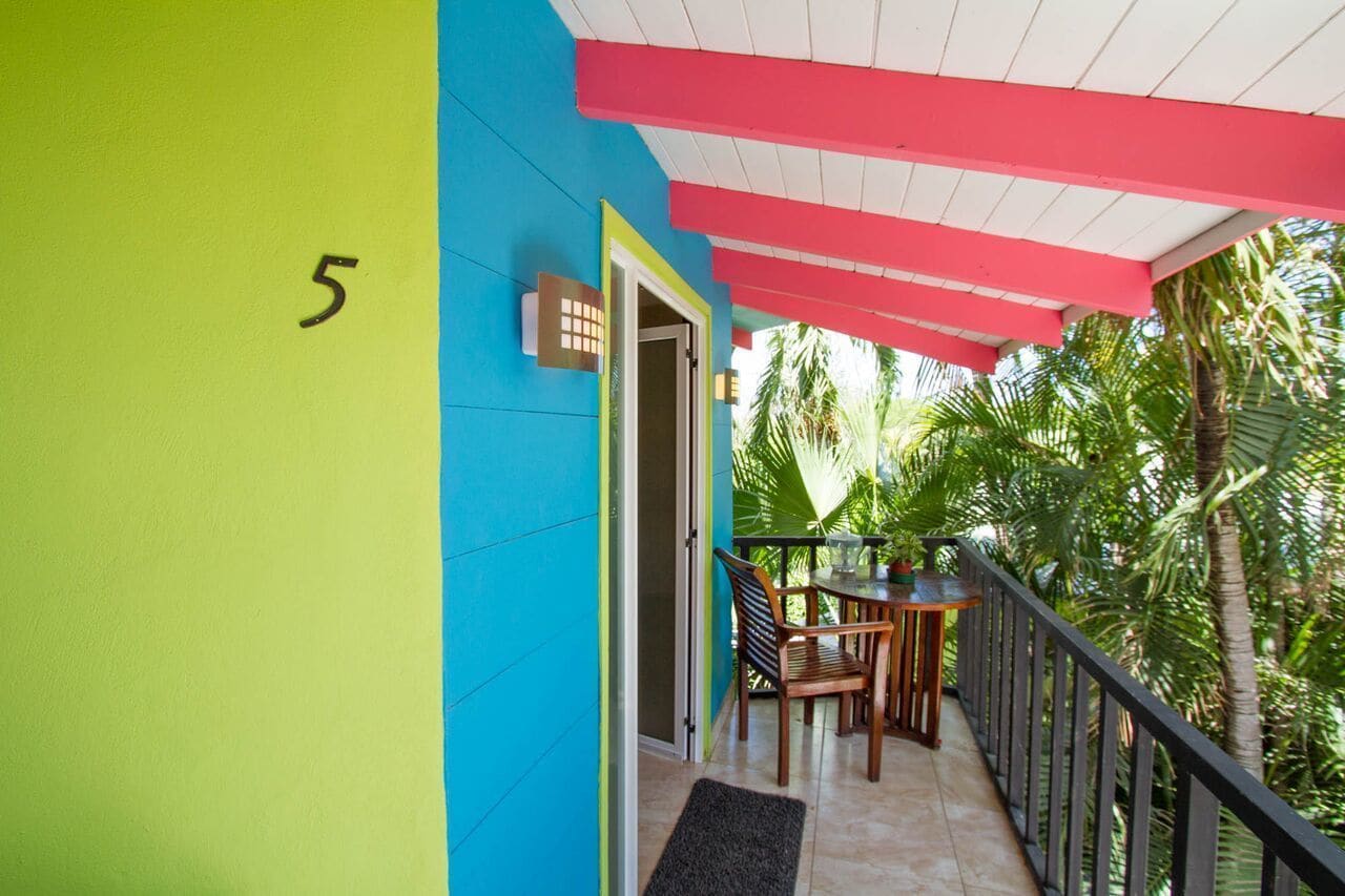 Un balcon avec une table et des chaises, une porte et le chiffre « 5 » peint sur le mur.