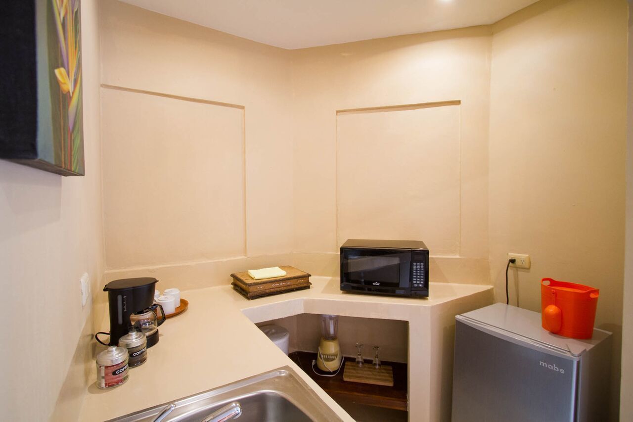 A compact kitchenette with a microwave, coffee maker, and a small refrigerator.