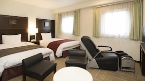A hotel room with two beds, a desk, a chair, a small table, and a TV. - Ariston Inn Kanda Kitakyushu Airport (Kanda)