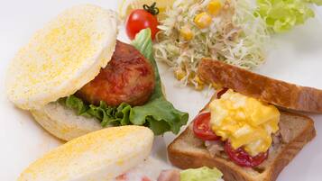 Ein Teller mit Sandwiches, einem Salat und einer Tasse Kaffee.