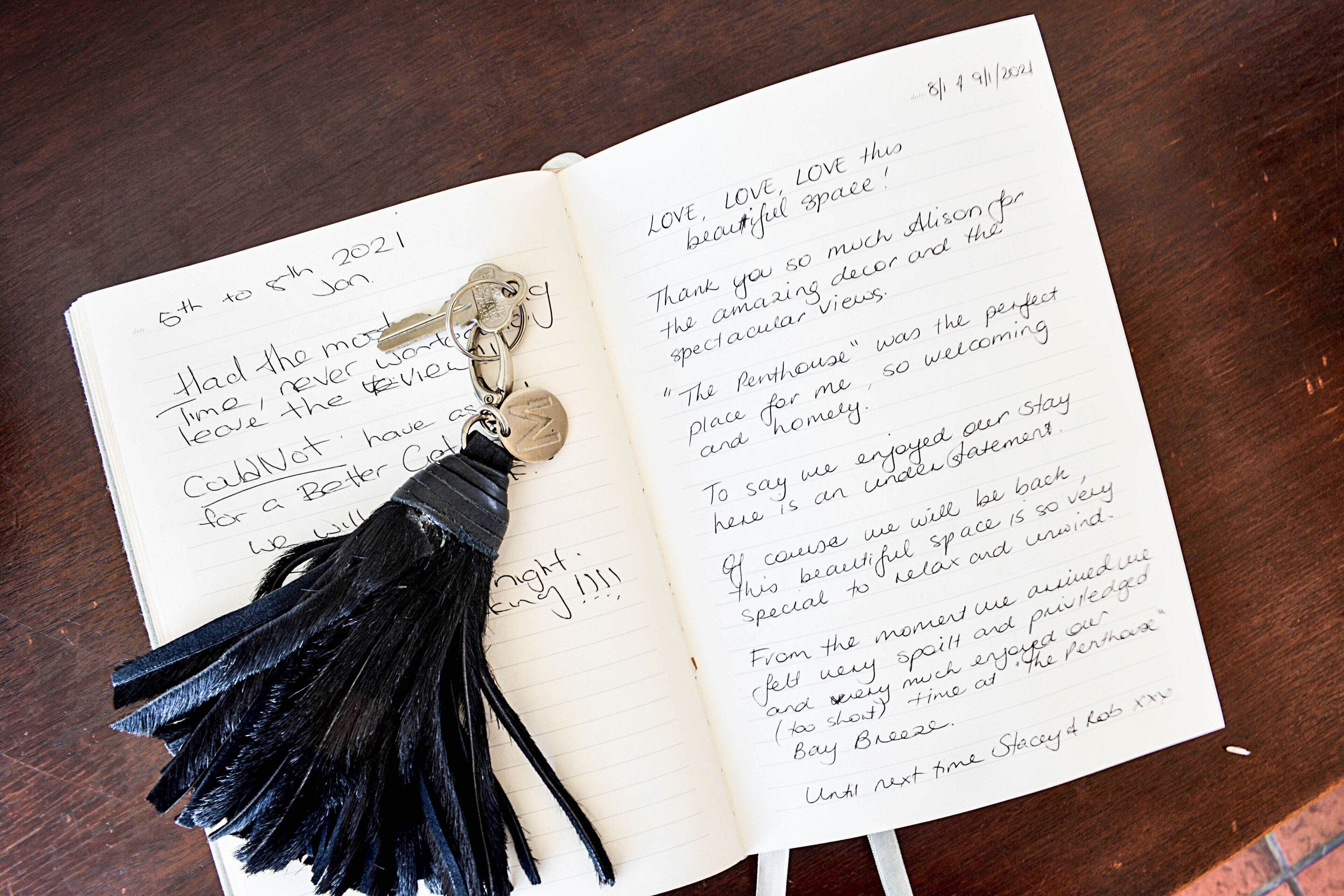 Un carnet ouvert avec des notes manuscrites et un porte-clés à pompon noir.