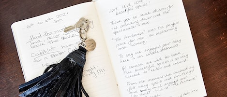 Un carnet ouvert avec des notes manuscrites et un porte-clés à pompon noir.