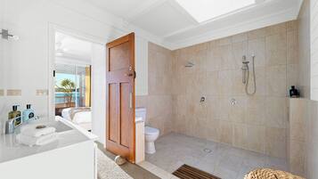 A bathroom with a shower, toilet, and sink.