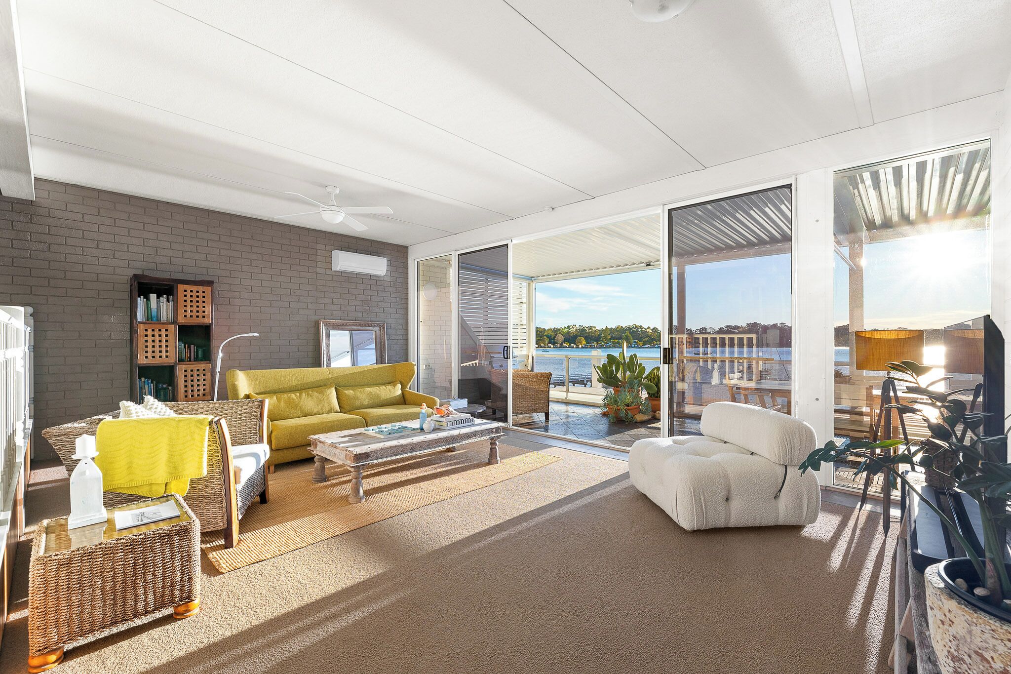 Un amplio espacio de sala con sofá, mesa de centro y vista al exterior.