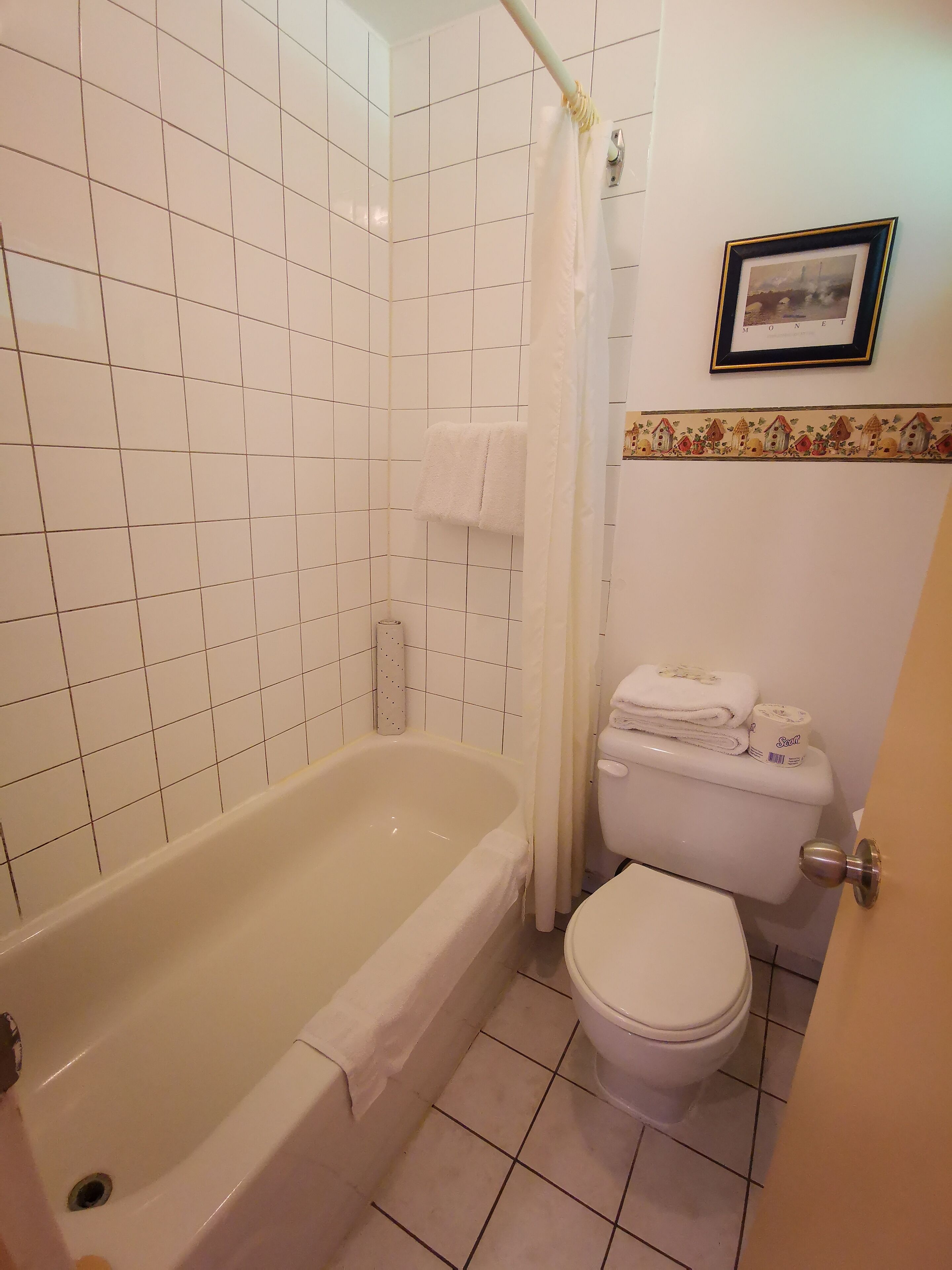 Un baño con bañera, inodoro y cortina de ducha.