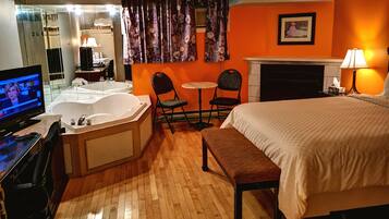 Chambre, 1 grand lit, baignoire à remous (Fireplace) | Bureau, fer et planche à repasser, accès au Wi-Fi (inclus)