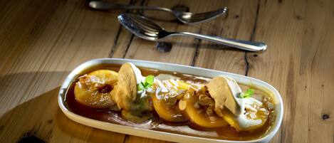 A dessert dish on a wooden table with a spoon and fork nearby.