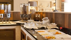 Ein reichhaltiges Buffet mit verschiedenen Speisen und einer Kaffeestation.