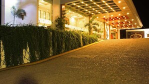 A hotel entrance with a paved driveway leading to a covered area with string lights. - Hotel Chennai Le Palace (Chennai)
