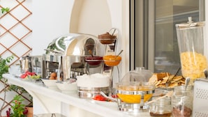 A buffet setup with various food items and condiments. - Olympic Hotel (Parga)