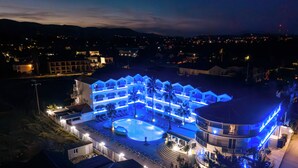 A large resort with multiple swimming pools, a covered area, and a well-lit exterior. - Atlantis Hotel (Zakynthos)