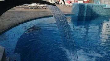 Relax by the pool with a soothing waterfall or water slide.