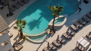 An aerial view of a resort with a large pool, sun loungers, and palm trees. - Atlantis Hotel (Zakynthos)