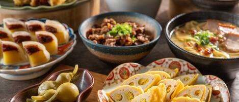A variety of dishes including dumplings, a bowl of pickled vegetables, and a plate of sliced meat with vegetables.