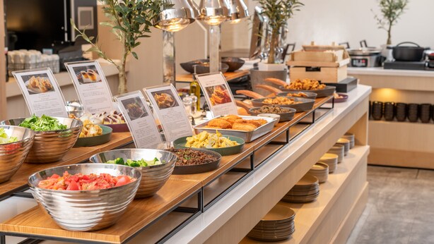 A buffet with various food items and a menu stand. - HOTEL MYSTAYS Kumamoto Riverside (Kumamoto)