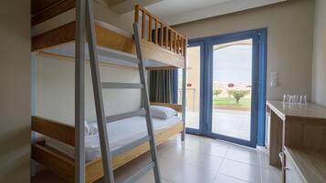 Una habitación con literas, una escalera, una puerta corrediza al exterior y un armario de madera.