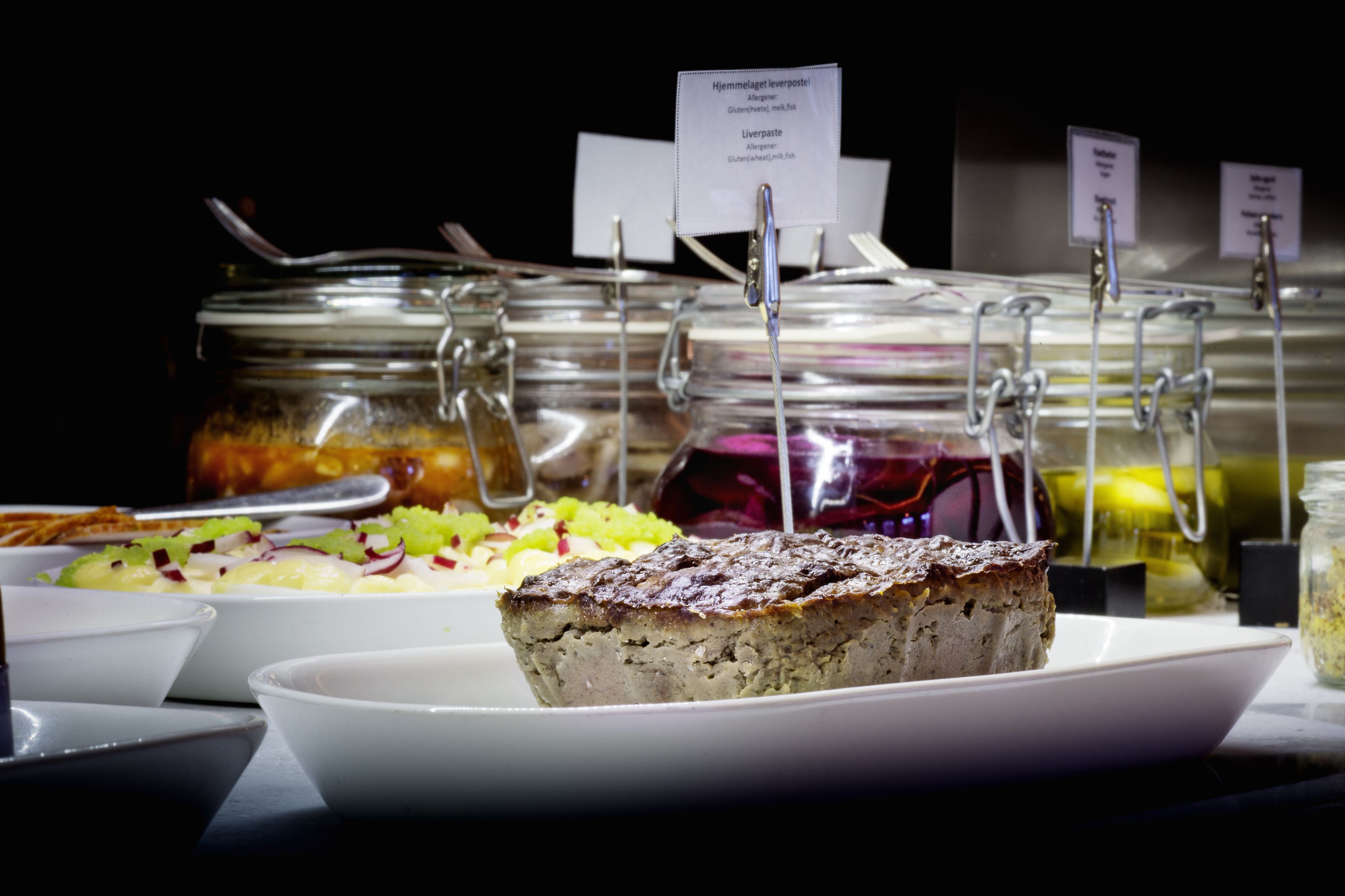 A buffet with various food items and labels.