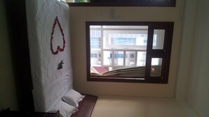 A room with a bed, a window, and a view of buildings outside. - Seaside Hotel 2 (Nha Trang)