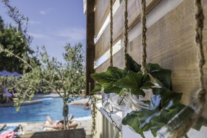 Una piscina al aire libre, sombrillas, sillones reclinables de piscina