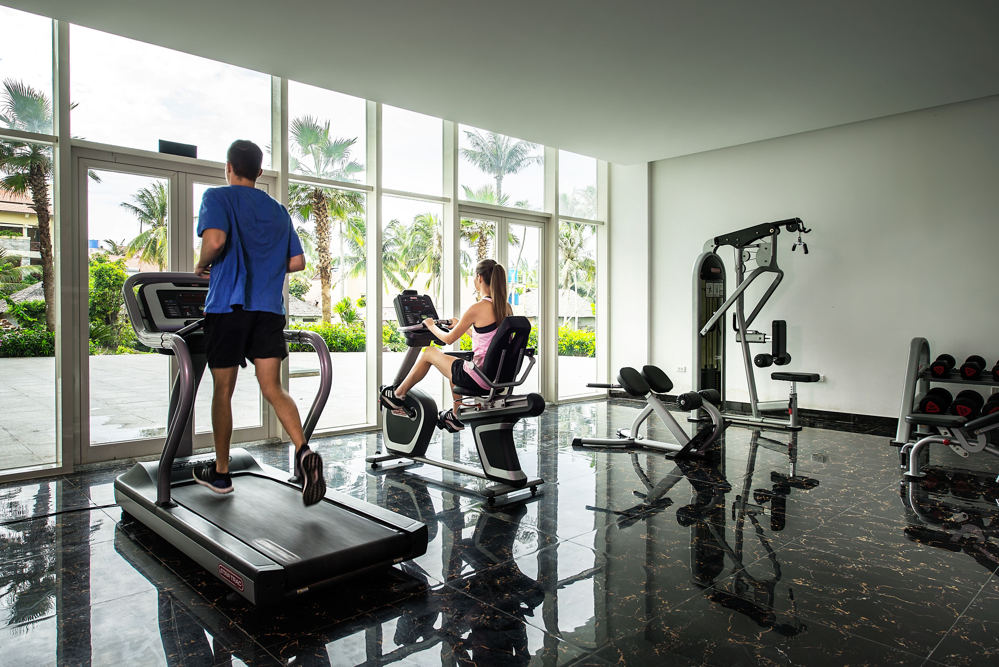 A gym with treadmills, stationary bikes, and weight machines.