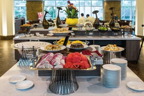 Ein reichhaltiges Buffet mit Speisen und einer dekorativen Vase mit Blumen.