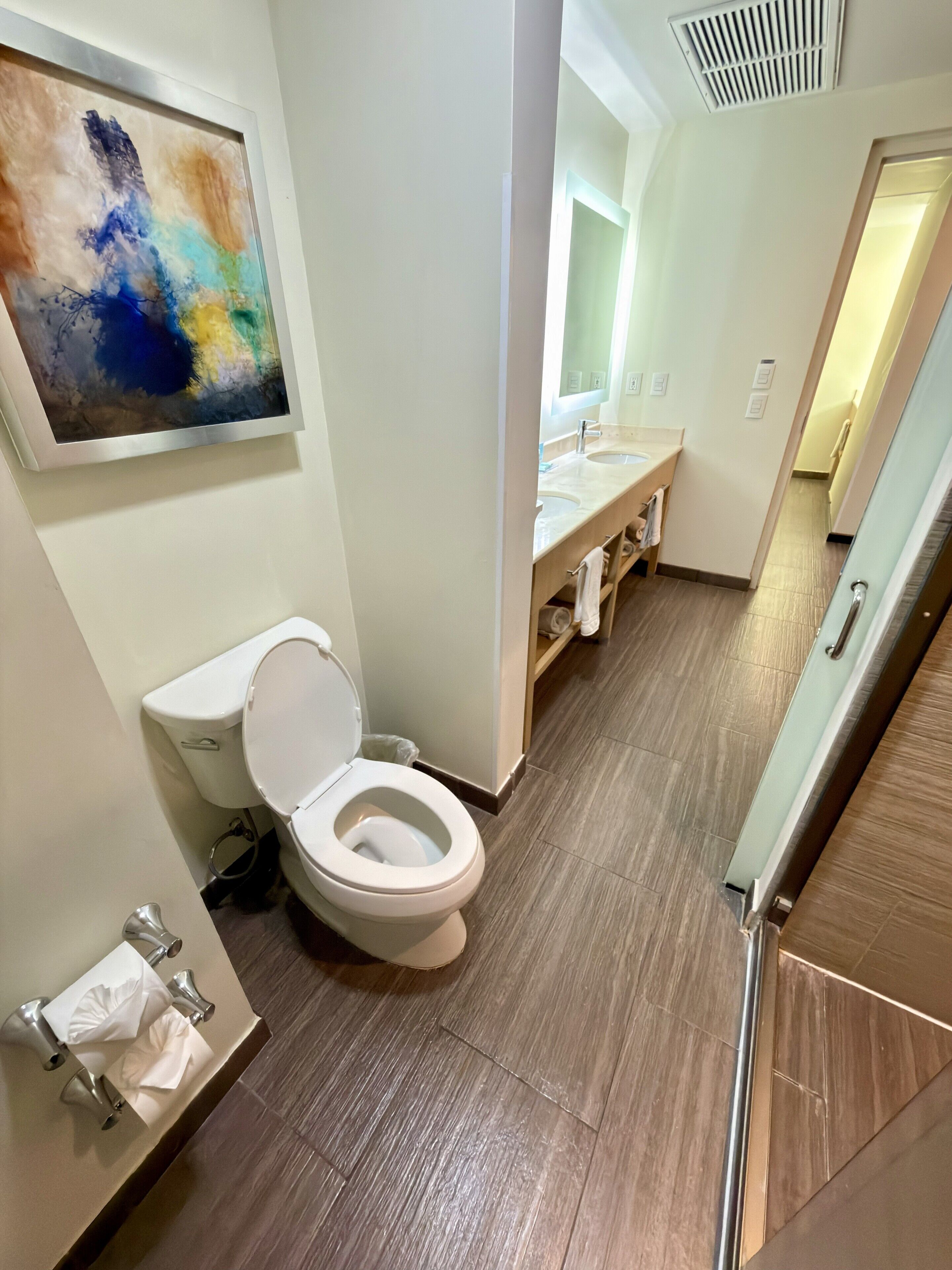 Un baño moderno con inodoro, lavamanos y zona de ducha.