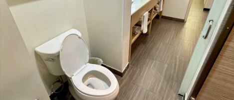 Un baño moderno con inodoro, lavamanos y zona de ducha.