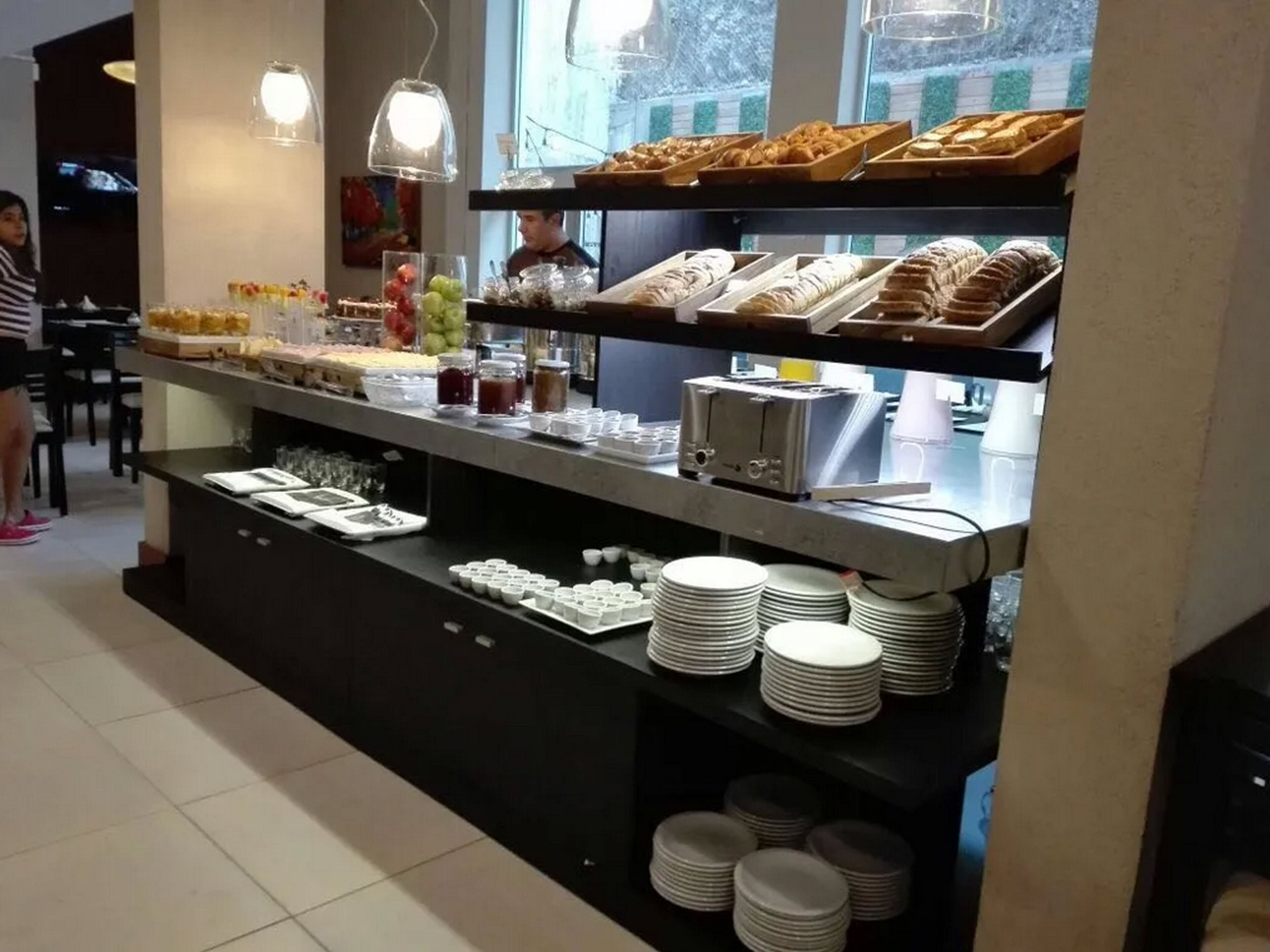 Una barra de buffet con diversos alimentos y utensilios.