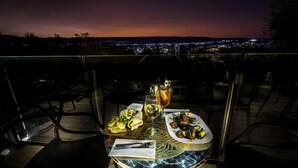 Een gedekte tafel voor het diner met uitzicht op de stad in de schemering.