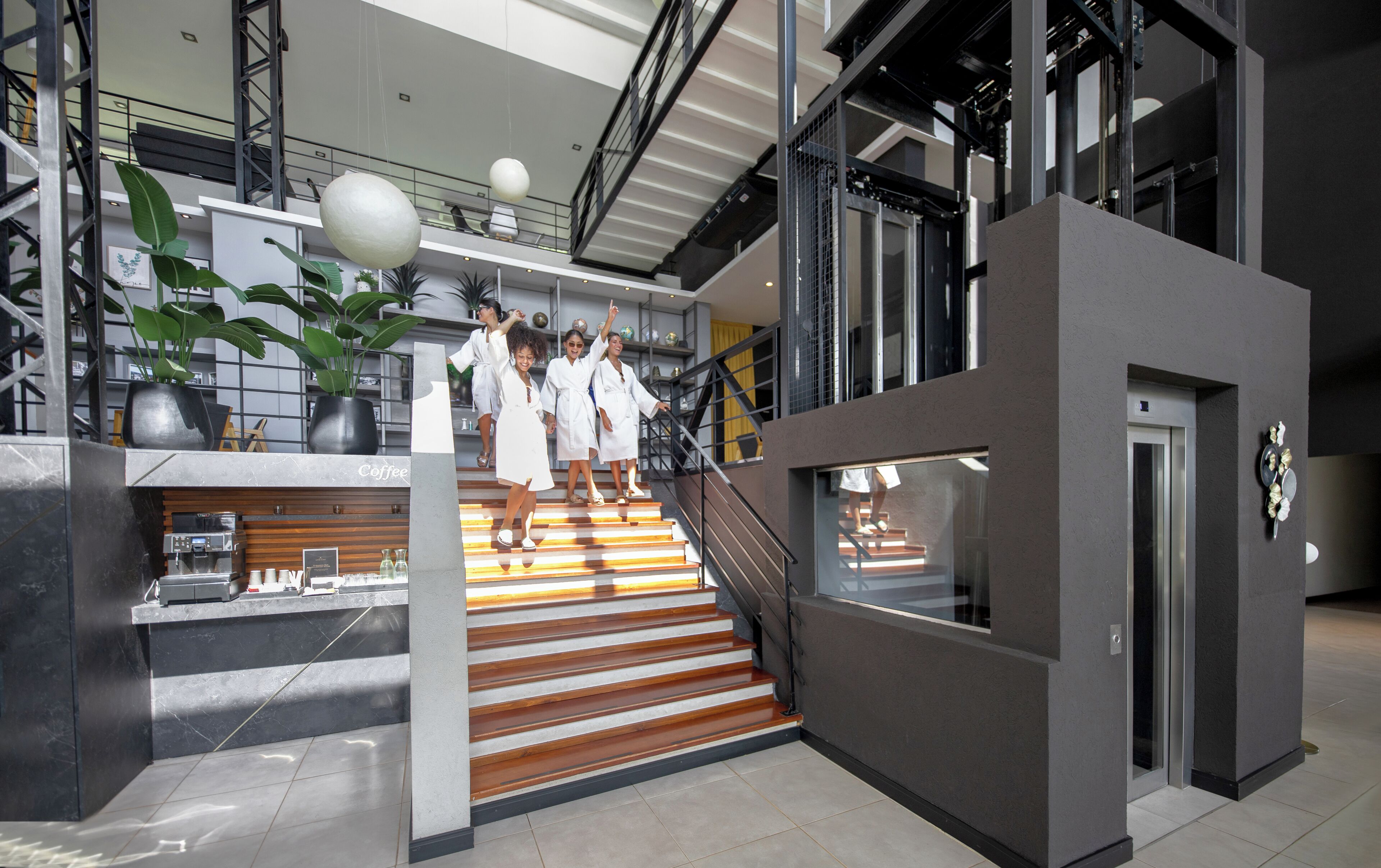 Een modern interieur met een trap, een koffiehoek en een receptie.