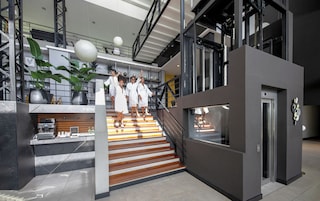 Un interior moderno con una escalera, una estación de café y una zona de recepción.