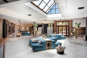 A spacious living area with a high ceiling, skylight, and a large window.