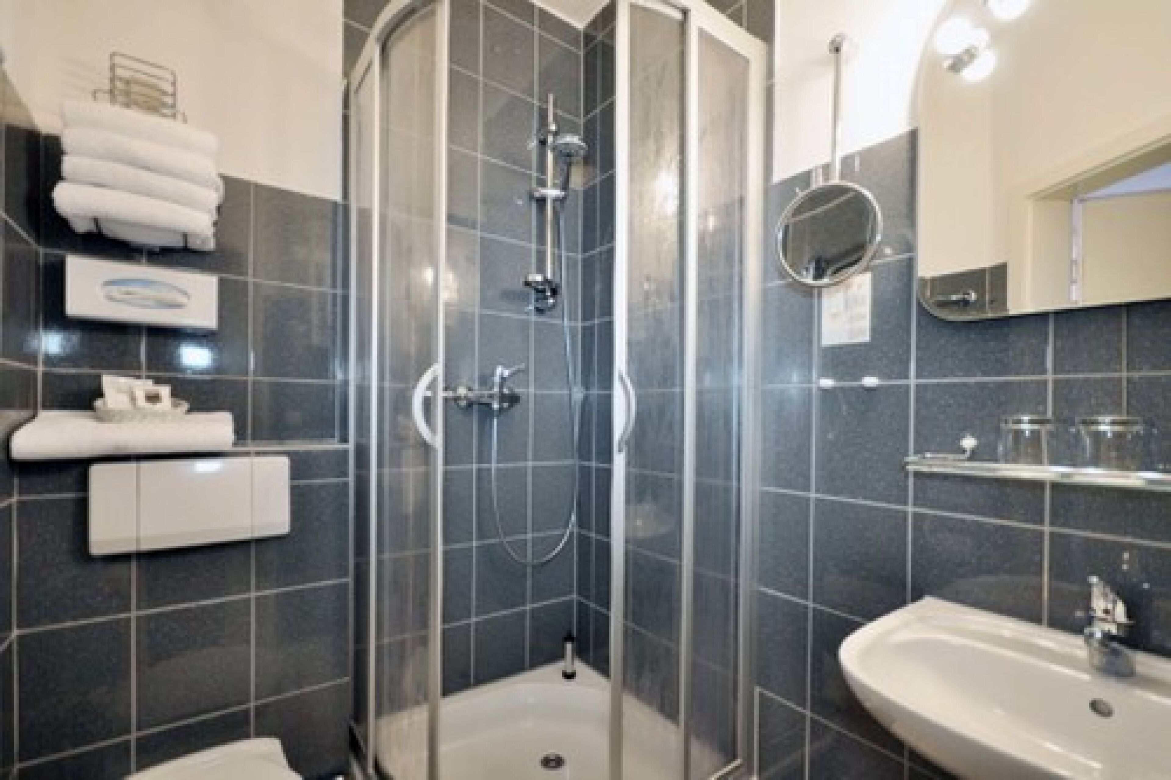 Une salle de bain moderne avec une douche à parois de verre, un lavabo et un miroir.