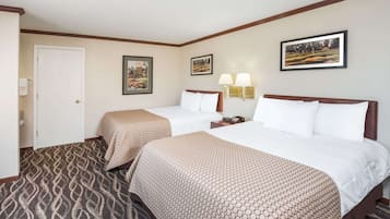 Ein Hotelzimmer mit zwei Betten, einem gemusterten Teppich und Wandleuchten.