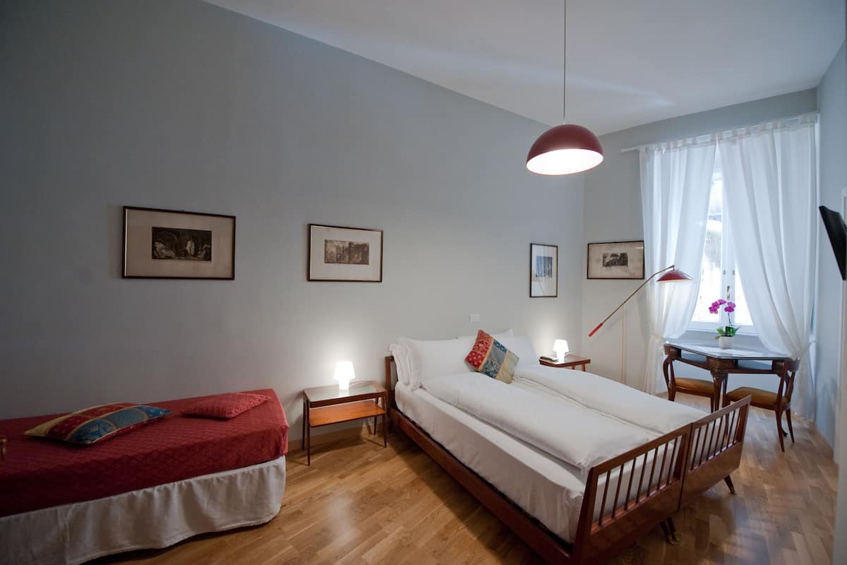 Un dormitorio con dos camas, un escritorio y una ventana con cortinas.