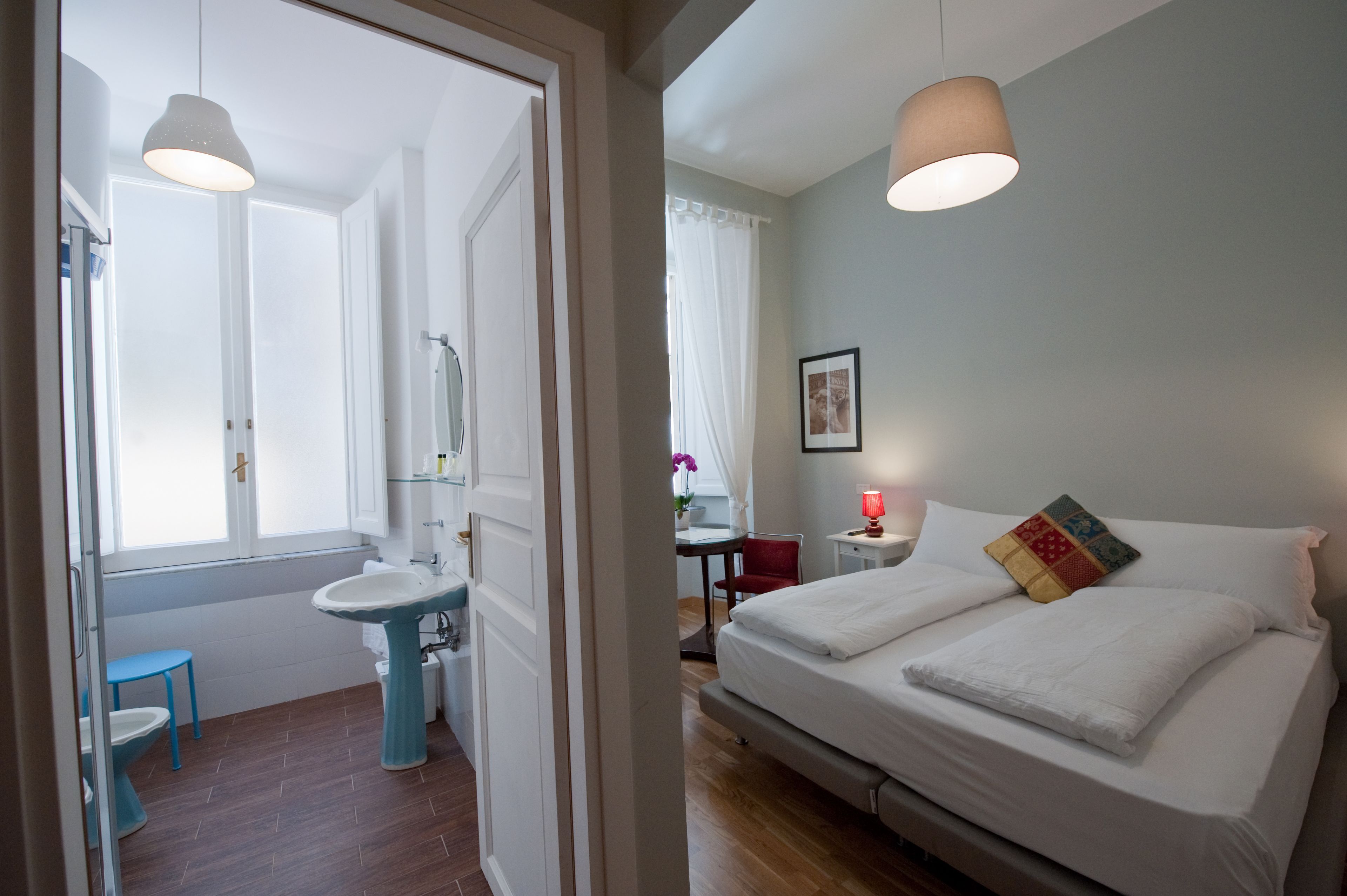 Une chambre à coucher avec un lit, une table de chevet et une fenêtre avec des rideaux.