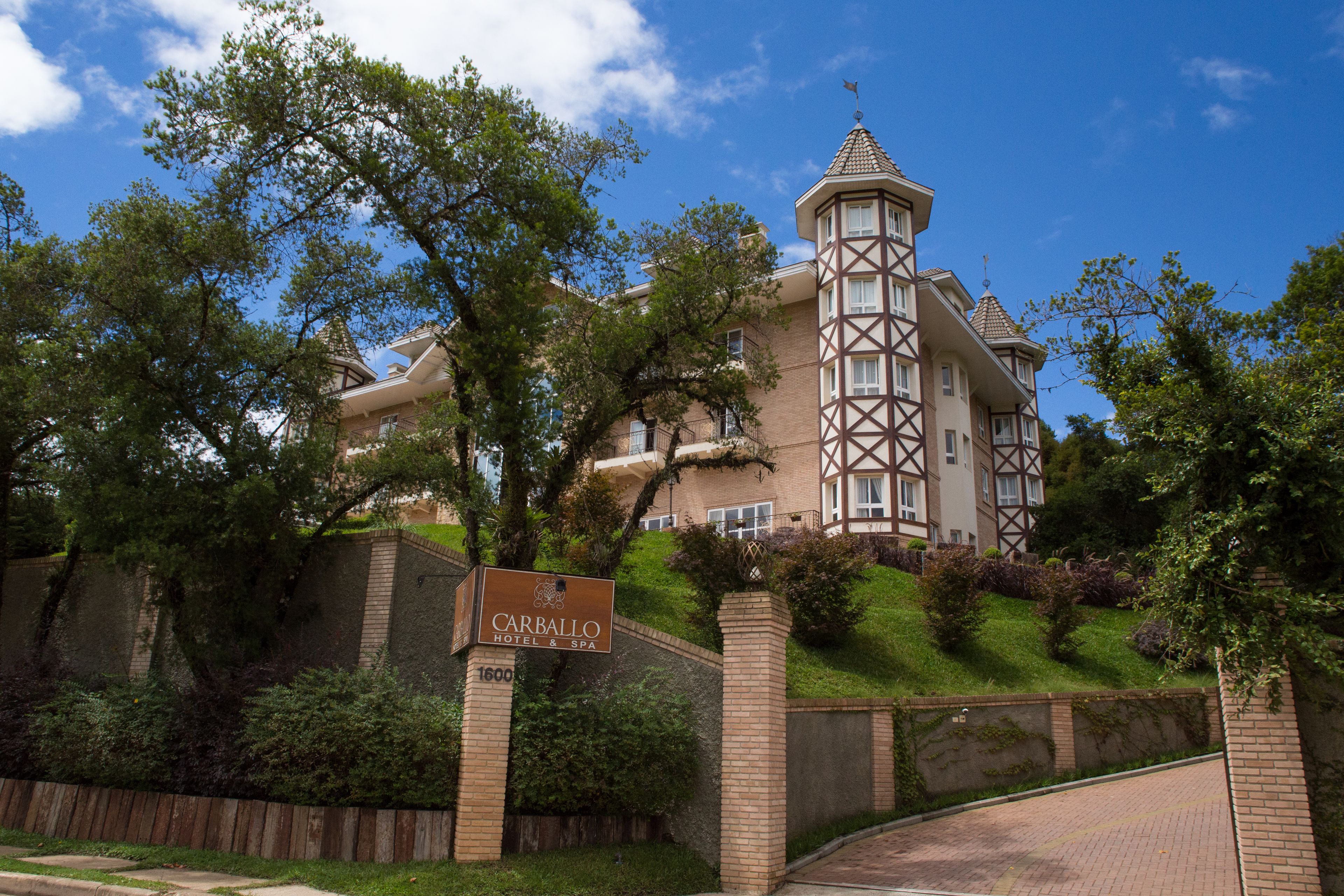 A large, historic hotel with a prominent tower and a sign reading "Carballo Hotel & Spa".