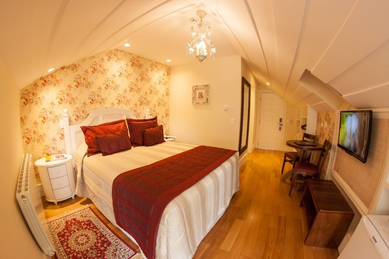 A bedroom with a bed, bedside table, and a TV.