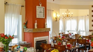 A buffet area with a variety of food items, a chandelier, and a clock on the wall.