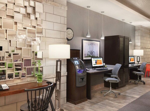 A modern office space with a desk, computer, and chair, a telephone, and a decorative wall with geometric patterns.