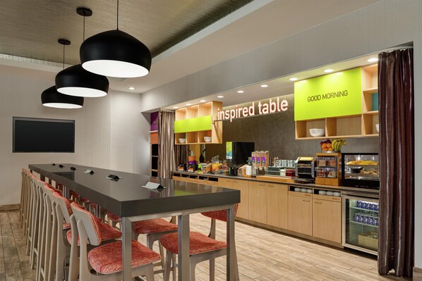 A modern meeting room with a long table, chairs, and a buffet area with food and drink options. - Home2 Suites by Hilton Austin North/Near the Domain (Austin)