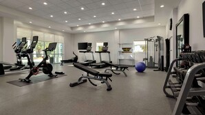 A gym with treadmills, elliptical machines, a bench press, and weightlifting equipment. - Home2 Suites by Hilton Austin North/Near the Domain (Austin)