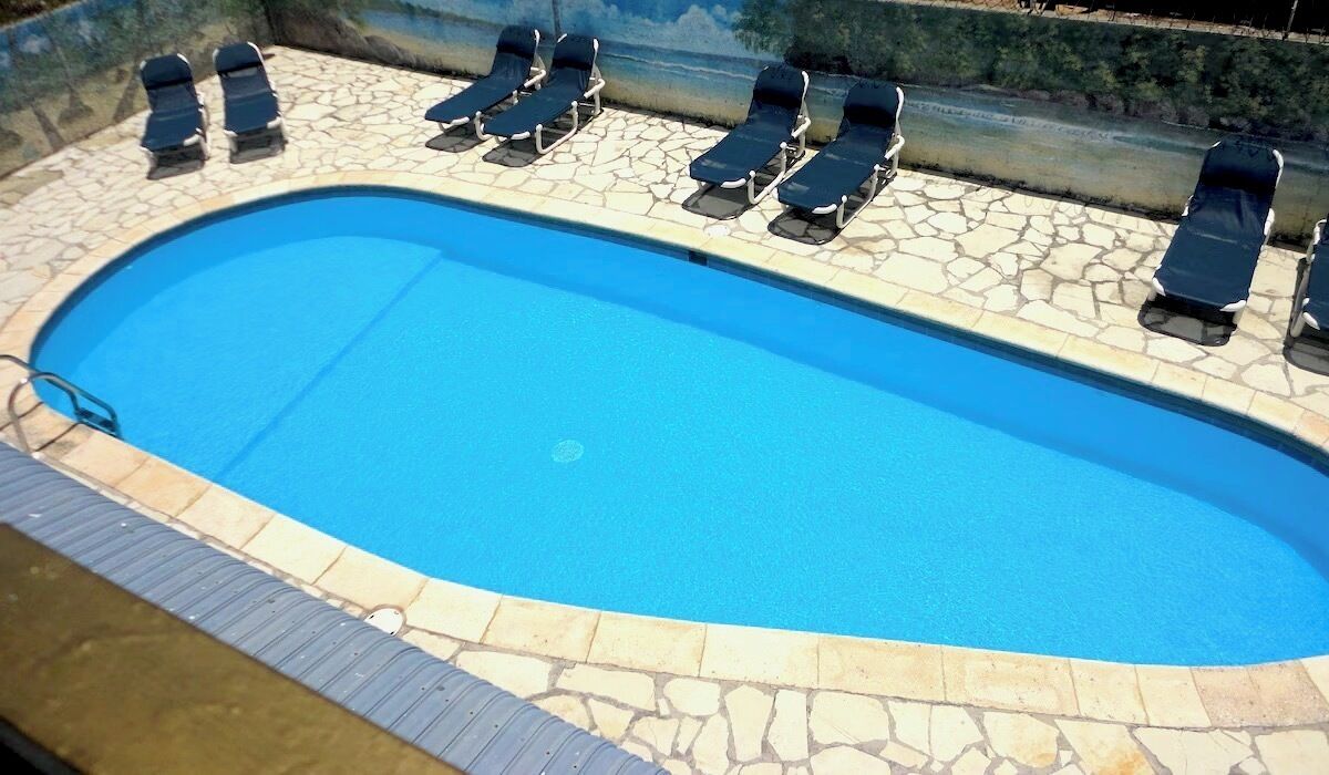 A swimming pool with lounge chairs arranged around it.