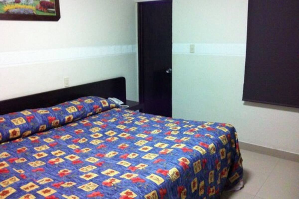Un dormitorio con cama, una puerta y una ventana.
