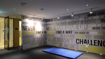 A gym with motivational quotes on the walls and a blue mat on the floor.